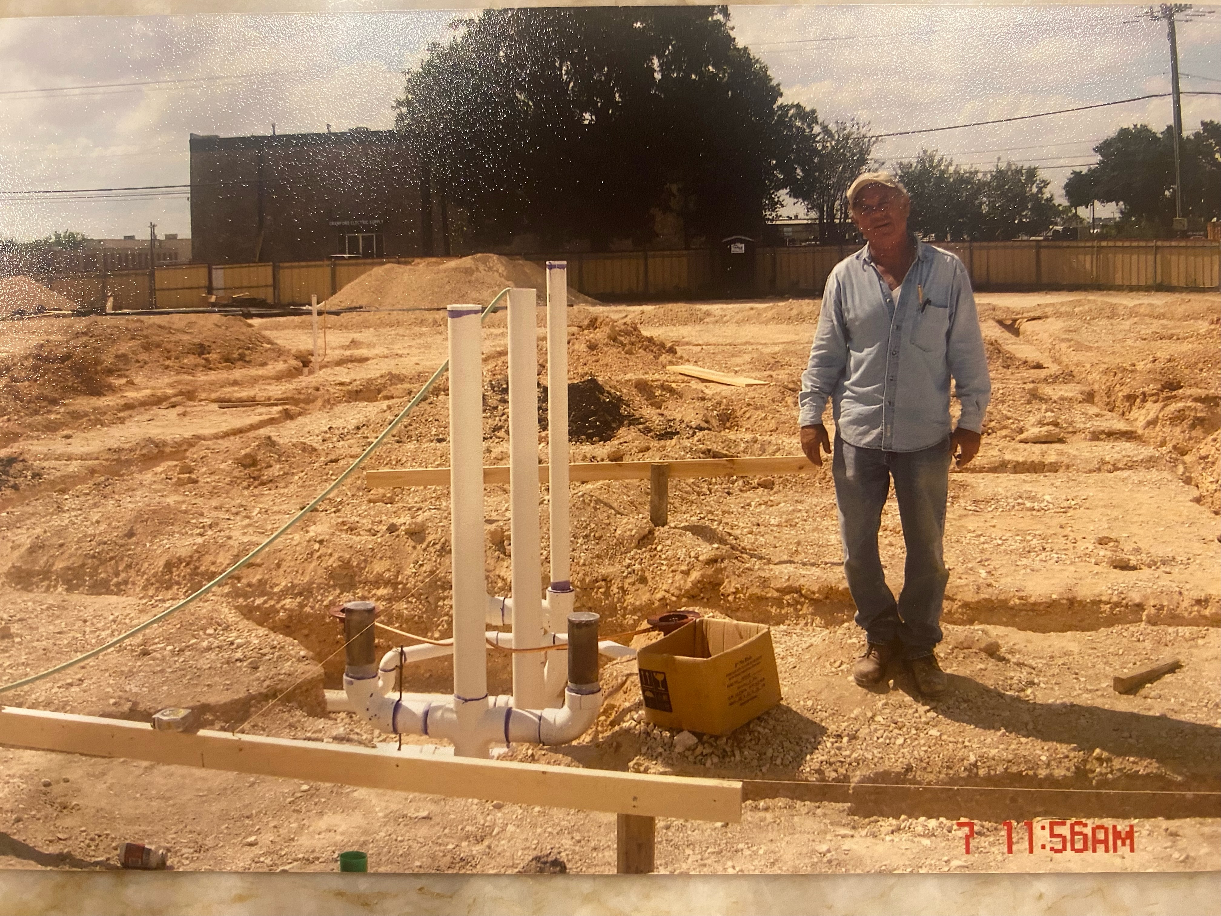 Rudy Sr. standing next to his plumbing work on a job site